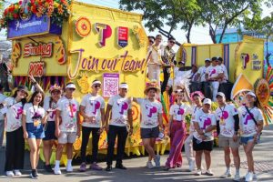 A group of people standing in front of a yellow float